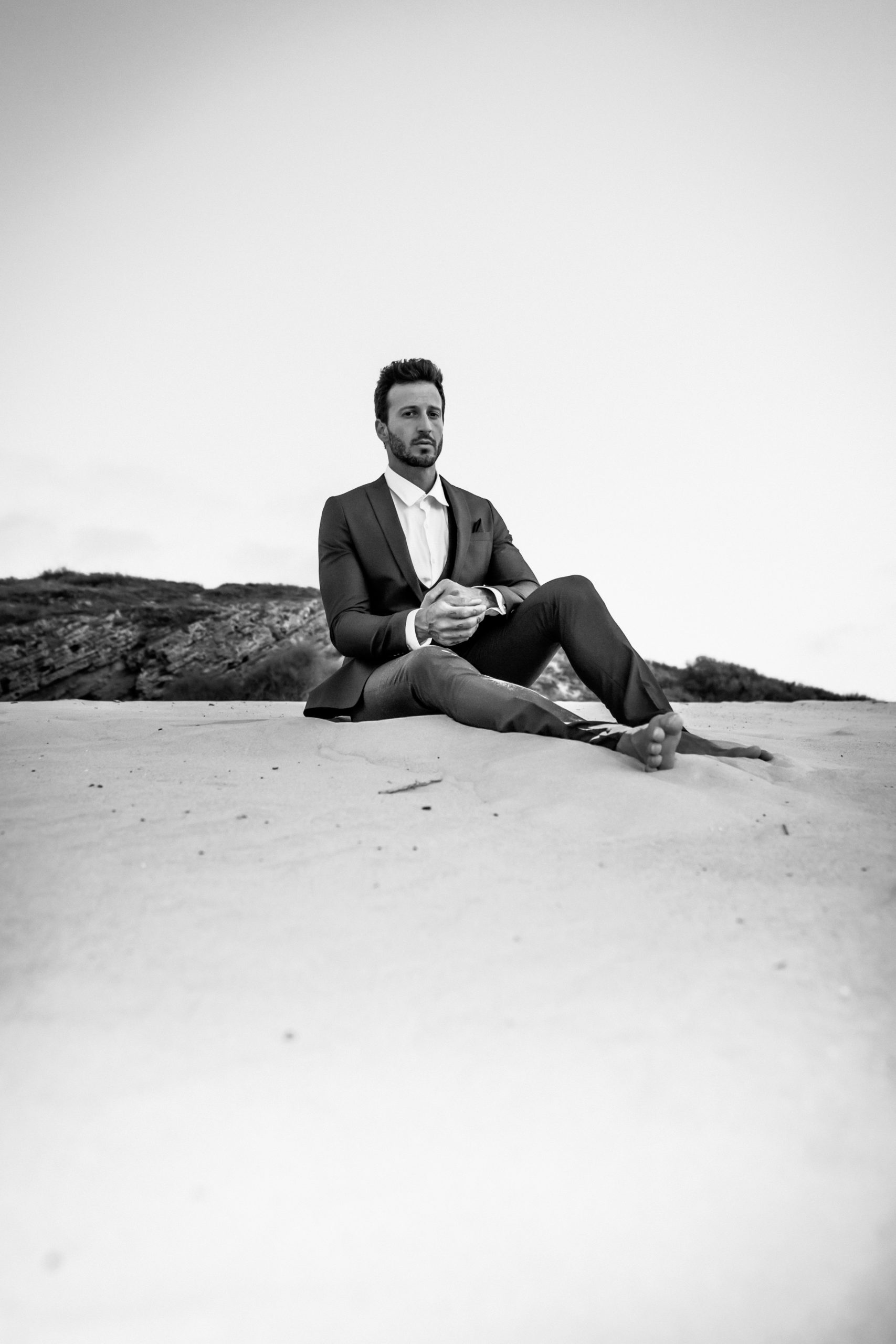 Michael Lewis sitting on the sand dunes gazing
